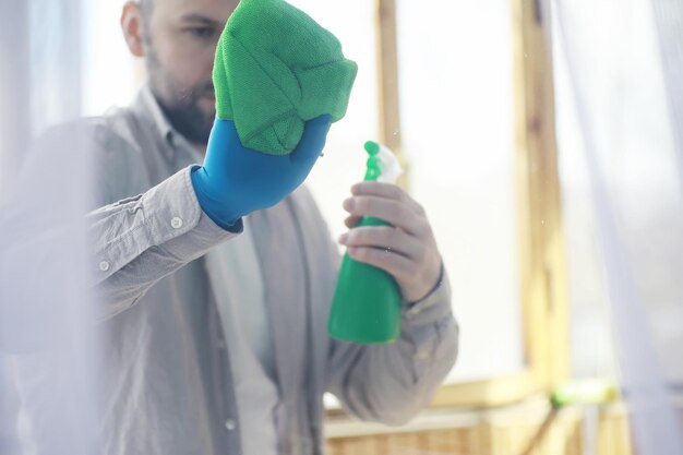 Concepto de limpieza de la casa. limpie el polvo de las superficies. tratamiento desinfectante de tiradores de puerta tv eléctricos. tratamiento sanitario a domicilio en cuarentena.