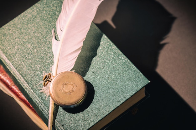 Concepto de literatura. Bodegón vintage con pluma o canilla, reloj vintage de libros antiguos.