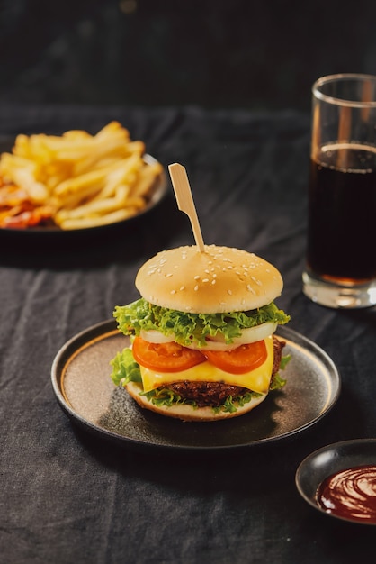 Concepto malsano. comida poco saludable: hamburguesa, salsa, patatas, cola.