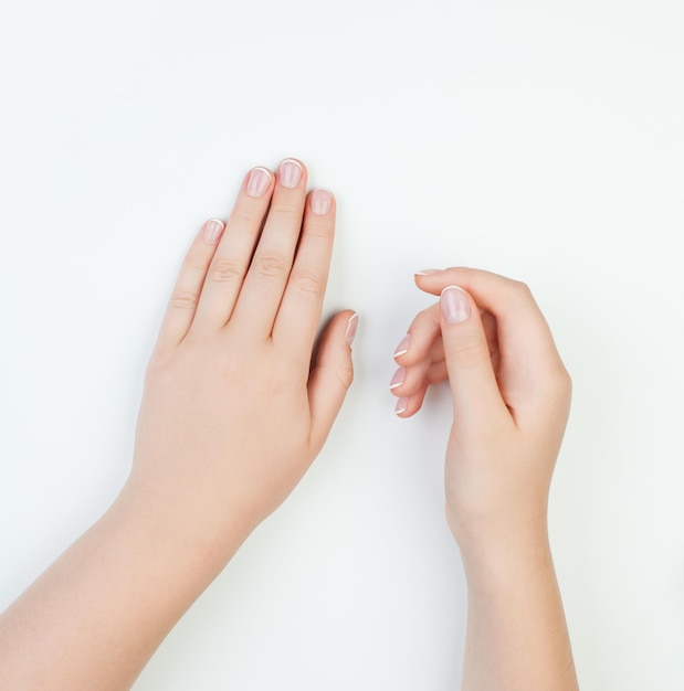 Concepto de manicura manos femeninas sobre fondo blanco.