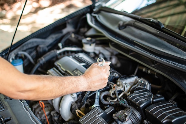 Concepto de mantenimiento del motor Los mecánicos sostienen una llave inglesa para apretar los pernos en las reparaciones del motor