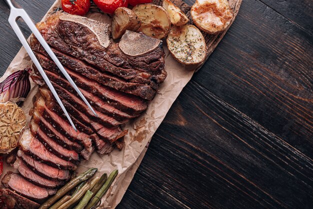 concepto de una maravillosa cena para dos de un delicioso y jugoso filete de res veteado de granjero a la parrilla con verduras al horno