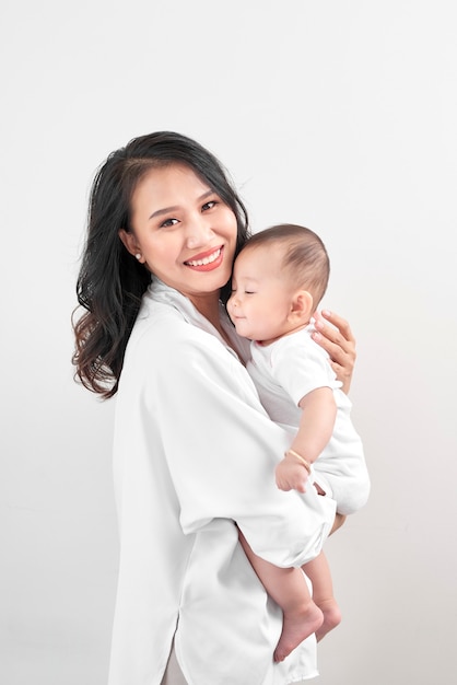 Concepto de maternidad y estilo de vida. Sonriente joven madre con bebé en casa