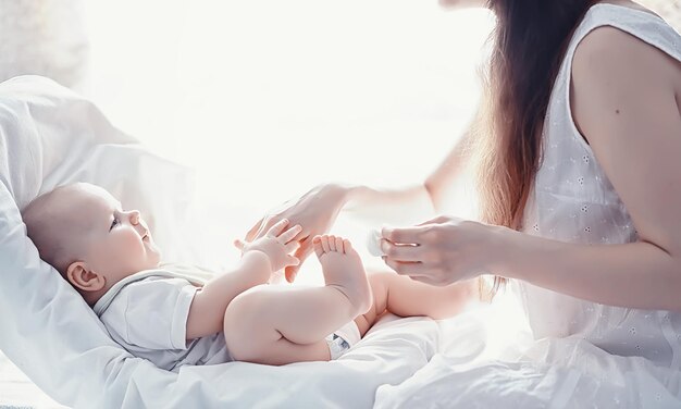 Concepto de maternidad Una joven madre alimenta a su pequeño bebé Primer señuelo y lactancia Familia numerosa vestida de blanco