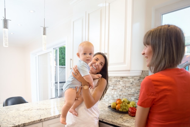 El concepto de maternidad, niñera, infancia e infancia. Tiro interior en la cocina.