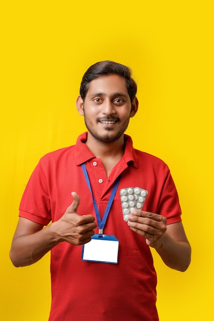 Concepto de medicina online: repartidor indio con tira de medicina en la mano