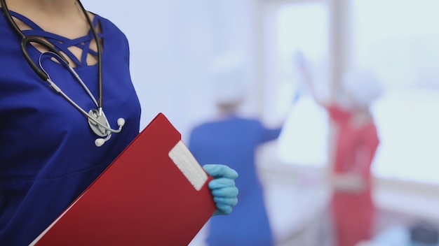 Foto concepto de medicina sanitaria. hospital del fondo del paciente del estetoscopio del traje rojo del doctor.