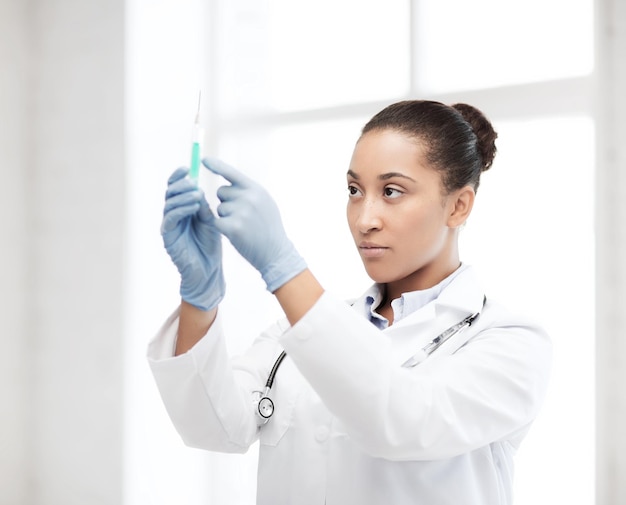 Foto concepto médico y de salud - médico africano sosteniendo jeringa con inyección