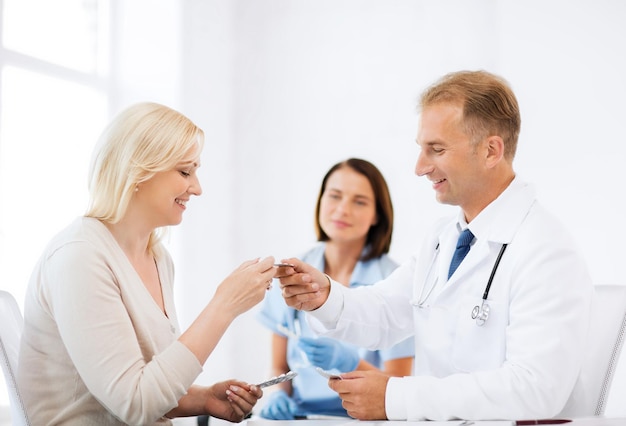 Concepto médico y sanitario - doctor dando tabletas al paciente en el hospital