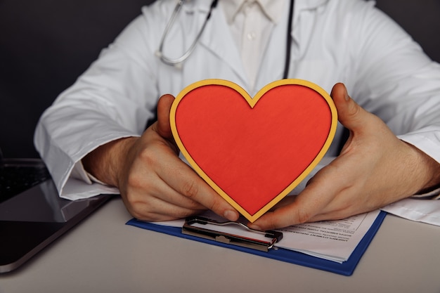 Foto concepto médico y sanitario. médico varón con corazón.