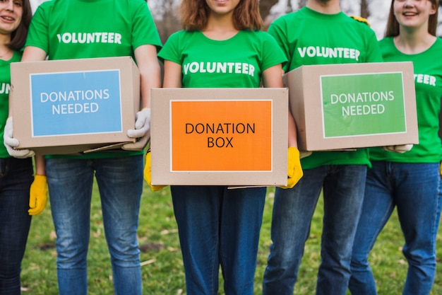 Foto concepto de medio ambiente y voluntarios con personas sujetando cajas para donaciones