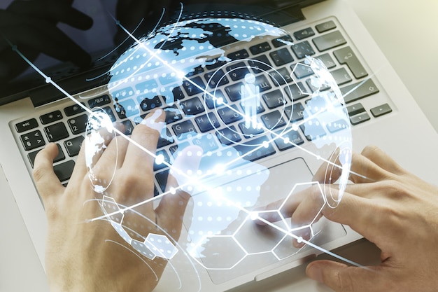 Concepto de medios de redes sociales con mapa mundial y manos escribiendo en el teclado de la computadora en segundo plano Exposición doble