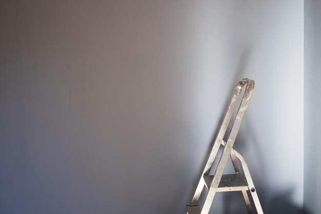 Concepto de mejoras para el hogar con escalera y pared blanca.