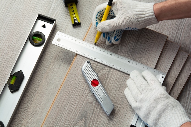 Concepto de mejoras para el hogar. hombre mide el nuevo laminado