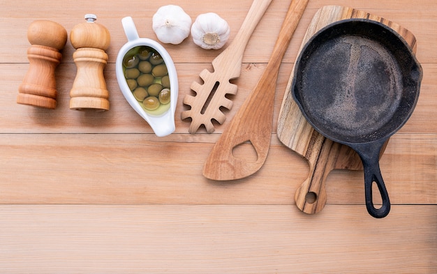 El concepto y el menú italianos de las comidas vacian la sartén del arrabio en la tabla de madera.