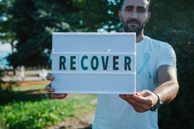 Foto concepto del mes de concientización sobre el cáncer de próstata. hombre con una cinta azul y recupera la palabra en el tablero.