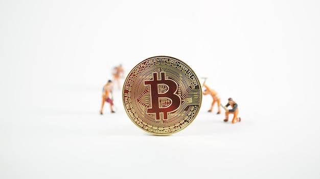 Concepto de minería de criptomonedas trabajador en miniatura en varios bitcoins de dinero digital físico dorado