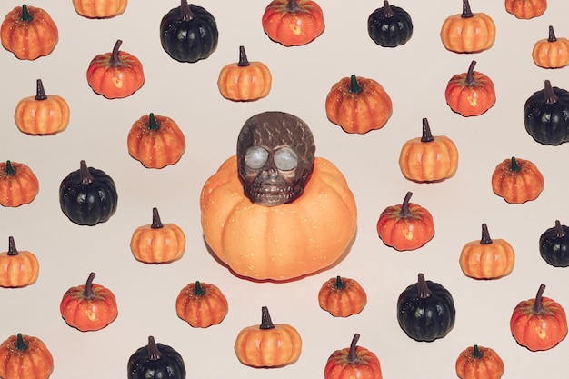 Concepto mínimo de Halloween con calabazas de colores y cráneo marrón Fondo de otoño espeluznante creativo