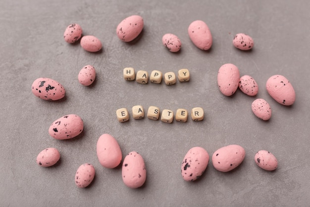 Concepto mínimo de Pascua Huevos de Pascua rosados con texto Feliz Pascua sobre fondo gris