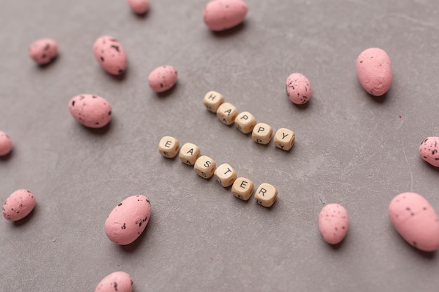 Concepto mínimo de Pascua Huevos de Pascua rosados con texto Feliz Pascua sobre fondo gris