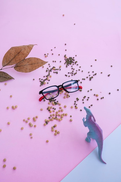 Concepto de moda y belleza acostado con gafas cuadradas accesorios de mujer sobre fondo rosa