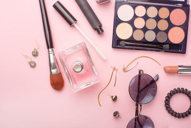 Concepto de moda de blog de belleza estilo femenino de accesorios cosméticos gafas perfumes sombras de ojos tush sobre un fondo rosa vista plana superior fondo femenino de moda endecha plana