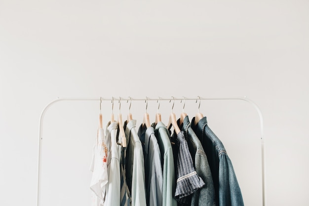 Concepto de moda mínima. Ropa femenina en percha en blanco