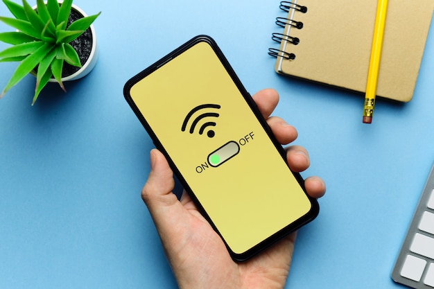 Foto concepto de modo wi-fi habilitado con teléfono inteligente en la mano.