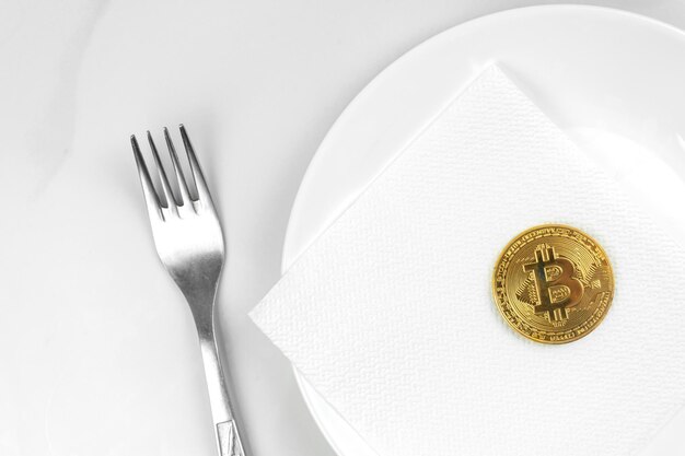 Concepto de moneda de oro de Bitcoin Imagen de medios mixtos de criptomoneda Bitcoin servido en una placa blanca Foto de fondo de mármol