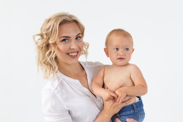 Concepto monoparental, la maternidad y la infancia - Madre con dulce niña en la pared blanca.