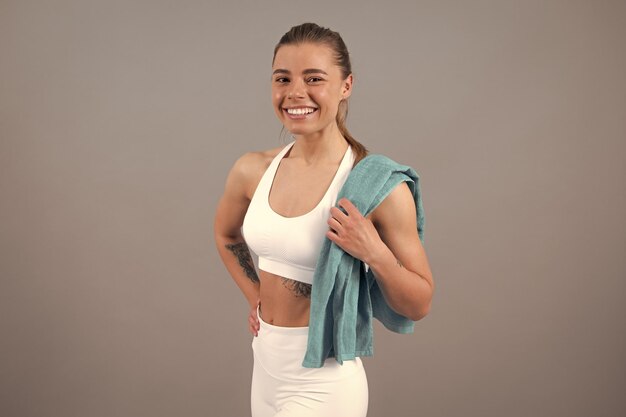 Foto concepto de motivación deportiva de entrenamiento retrato de joven instructor de fitness deportivo sonriente feliz con toalla concepto de deporte de entrenamiento