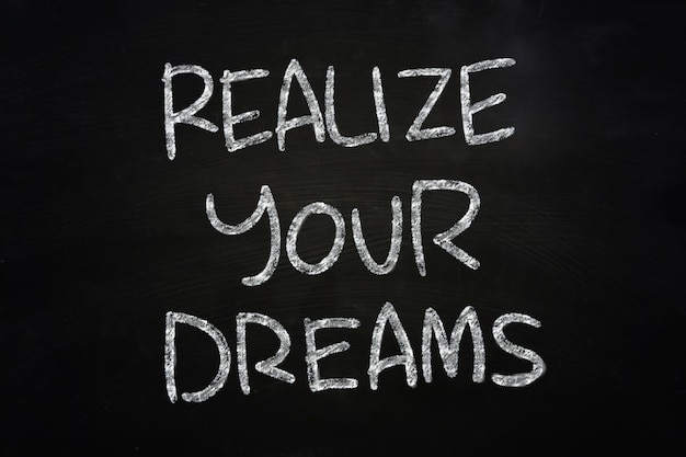 Concepto motivacional las palabras Realize Your Dreams escritas con tiza en la pizarra