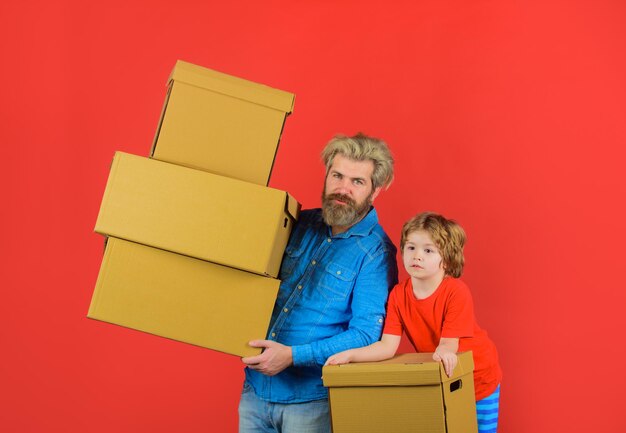 Concepto en movimiento feliz pequeño hijo y padre con caja de cartón, empaquetado de cosas, entrega y familia