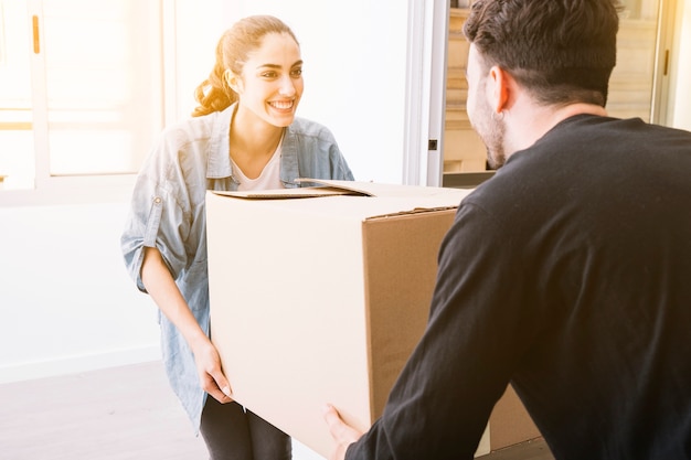 Concepto de mudanza con pareja llevando caja