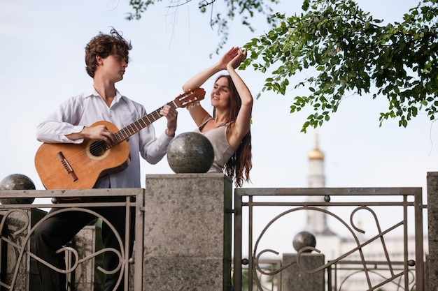 Foto concepto de música de guitarra de pareja de cita de ciudad romántica. bailando en la calle. felices juntos.