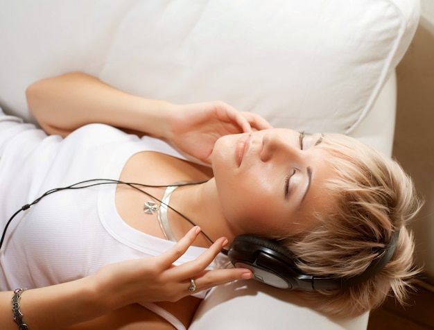 Concepto de música: mujer joven con auriculares