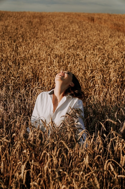 Concepto de naturaleza, vacaciones de verano, vacaciones y personas de verano. Cerca de feliz joven en los oídos de un campo de centeno