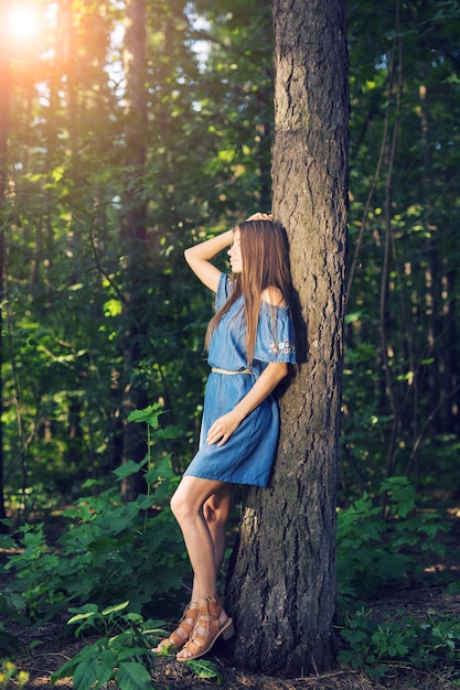 Concepto de naturaleza, verano y personas - mujer joven posando en el bosque verde.