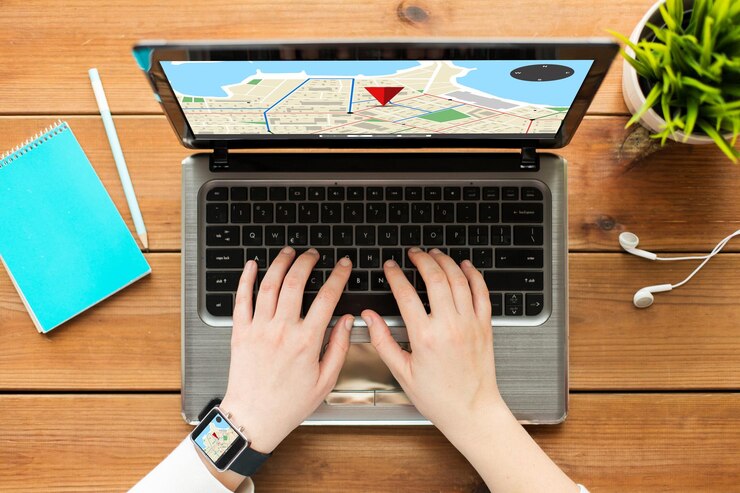 Foto concepto de navegación, ubicación, personas y tecnología: cierre de una mujer o estudiante escribiendo en una computadora portátil con un mapa de navegador gps en pantalla, portátil y auriculares en una mesa de madera