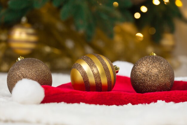 Concepto de navidad. Adornos de oro en el sombrero de Santa Claus y el árbol de Navidad