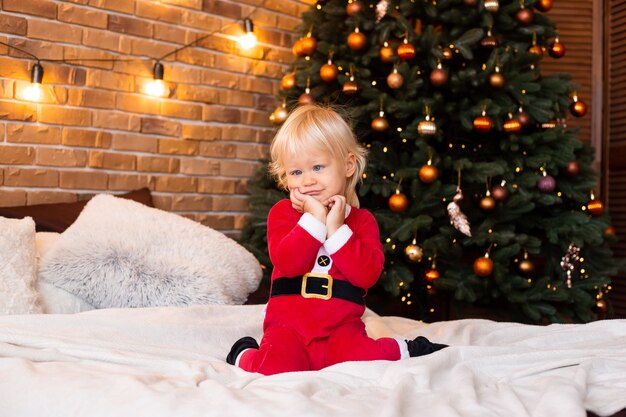 Concepto de navidad. Año nuevo. Niño cerca de un árbol de Navidad