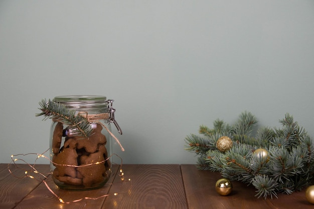 Concepto de navidad bote de vidrio con galletas de jengibre árbol de pieles de navidad sobre fondo verde