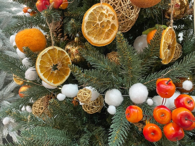 Concepto de navidad cero desperdicio Árbol de navidad decorado con adornos hechos de materiales naturales rodajas de naranja seca y conos