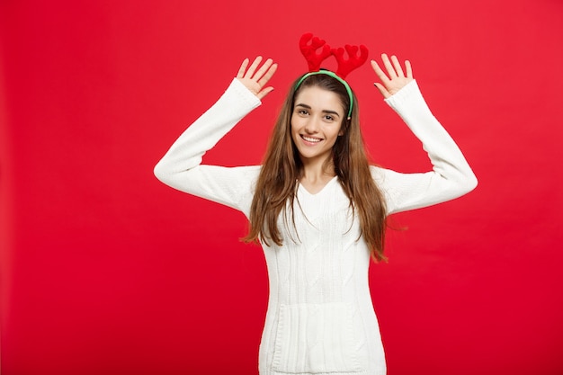 Concepto de Navidad - joven y atractiva dama caucásica usar diadema de renos celebrando en el día de Navidad.