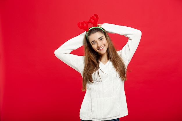 Concepto de Navidad - joven y atractiva dama caucásica usar diadema de renos celebrando en el día de Navidad.