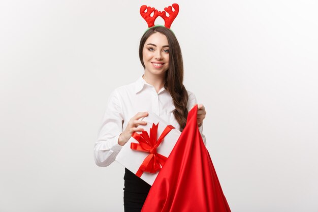 Concepto de Navidad - mujer de negocios hermosa joven feliz con presente en bolsa de santa.