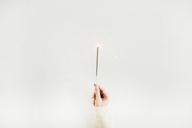 Foto concepto de navidad. mujer sosteniendo la luz de bengala. endecha plana