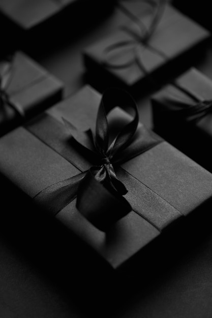 Concepto de Navidad Negra Cerca en elegantes regalos envueltos en matte negro con cinta enfoque selectivo