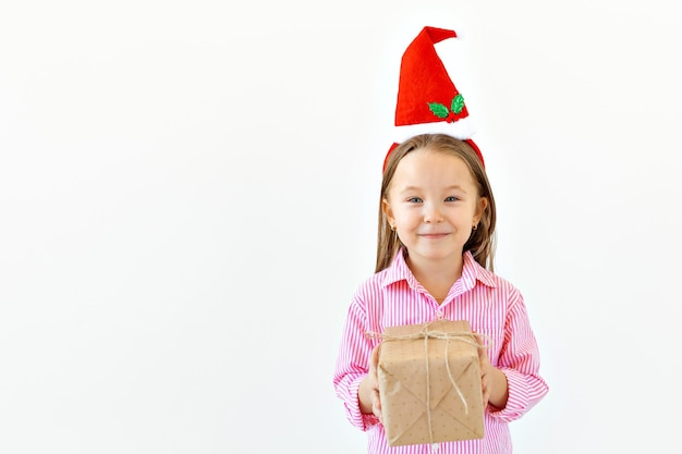 Concepto de Navidad - niña feliz sonriendo con caja de regalo sobre fondo blanco con espacio de copia