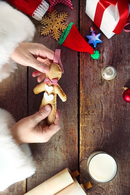 Concepto de navidad. Santa Claus hace juguetes de cerca. Adornos navideños en mesa de madera.